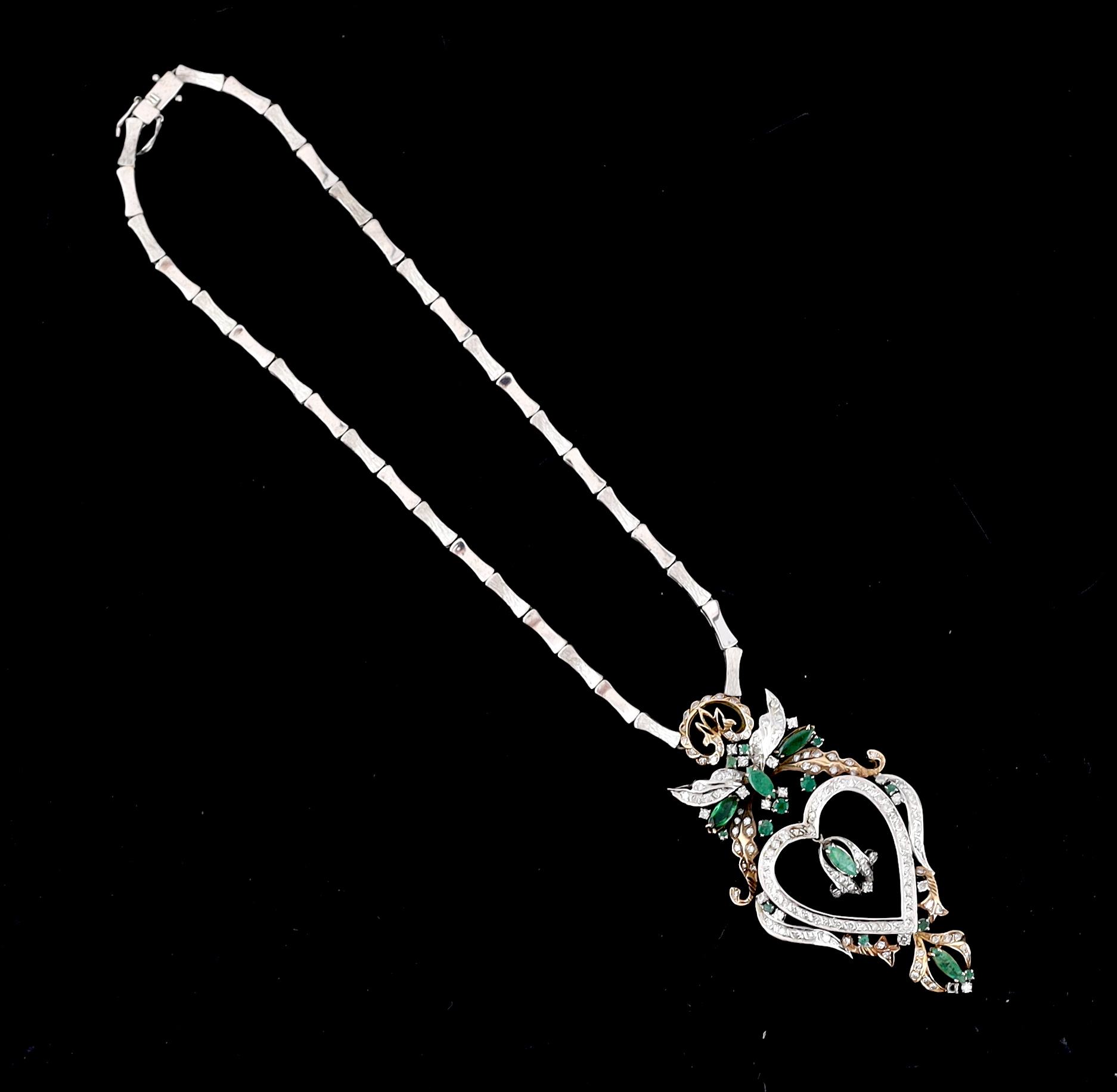 A late 20th century Middle Eastern two colour gold, emerald and diamond cluster heart shaped pendant necklace